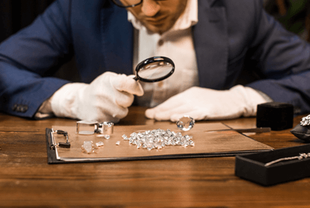 jeweler using magnifying glass to investiage diamonds