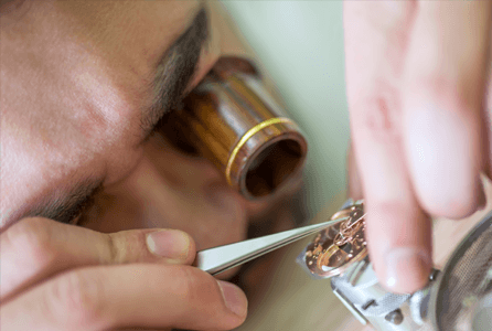 jeweler using loop to repair a watch